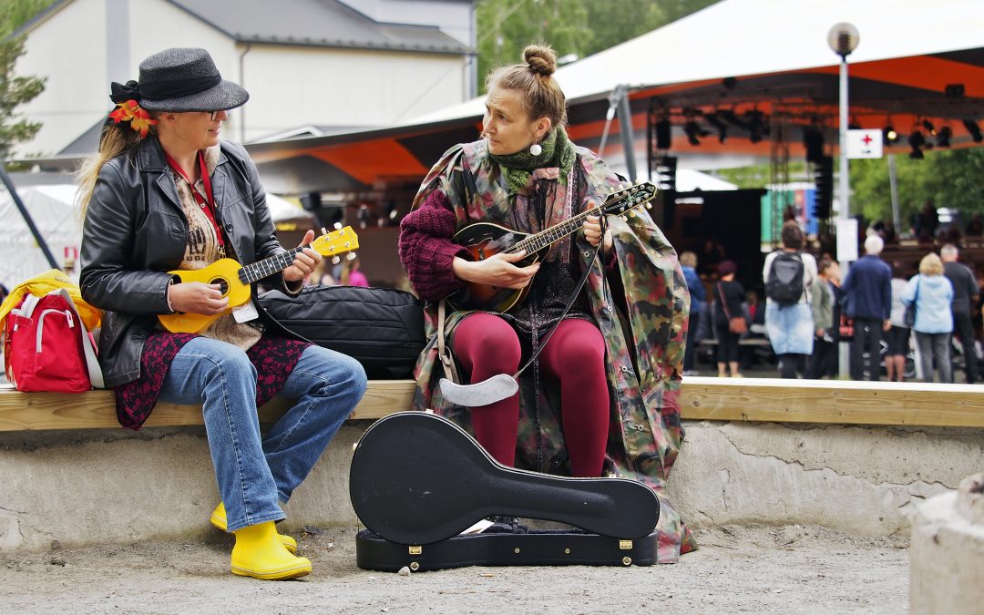 Kaksi pelimannia soittamassa Kaustisen kansanmusiikkijuhlien festivaalialueella pienen sateen ripsiessä. Kuvan on ottanut Arto Kuorikoski.