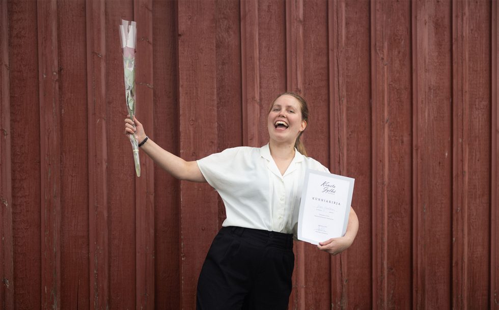 Kilpailun voittaja tuulettaa ruusu kädessä.