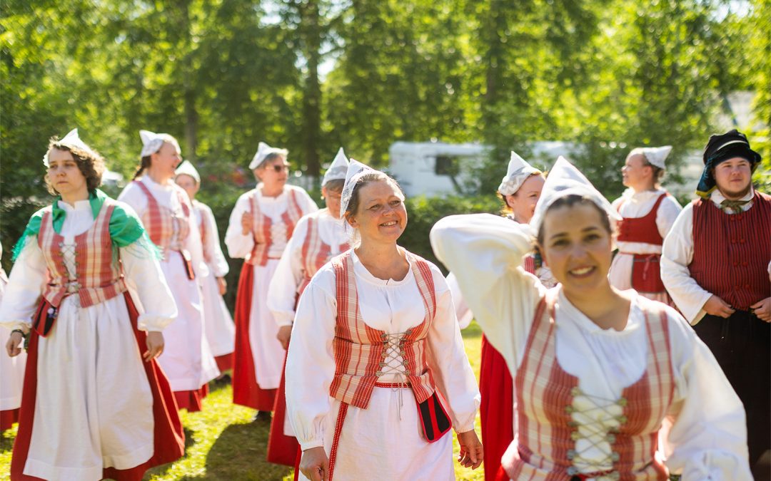 Onnellisen näköisiä naisia kansallispuvuissa.