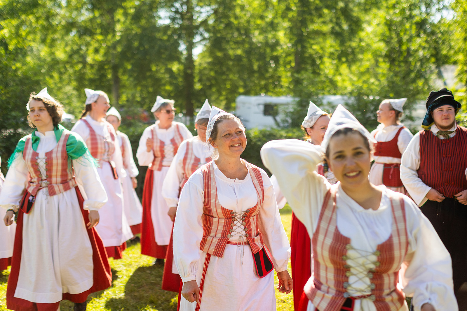 Onnellisen näköisiä naisia kansallispuvuissa.