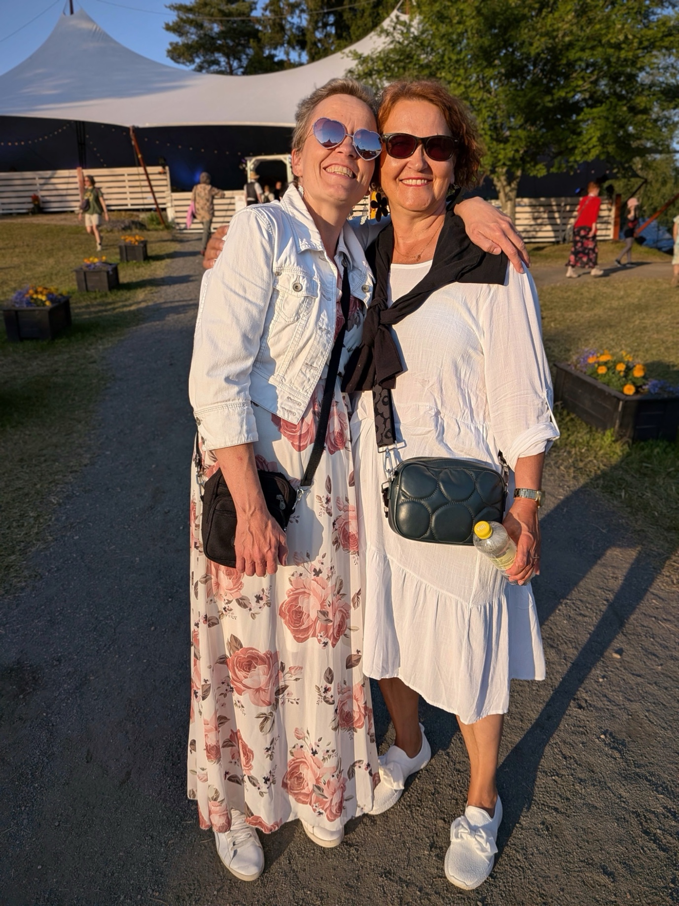 Marjo ja Merja fiilistelevät festareilla lämpimän ilta-auringon alla.